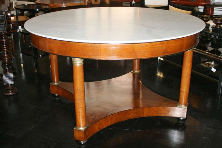 Early 19th century large Empire walnut centre table, white marble top, polished apron, four column legs with bronze mounts on shaped plinth base.