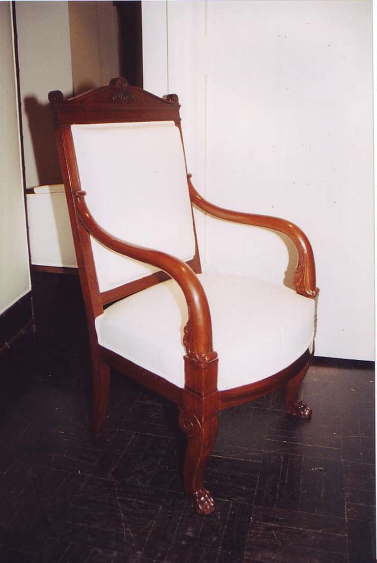 Late 19th century mahogany fauteuil, carved shaped cresting, downswept arms, paw feet.