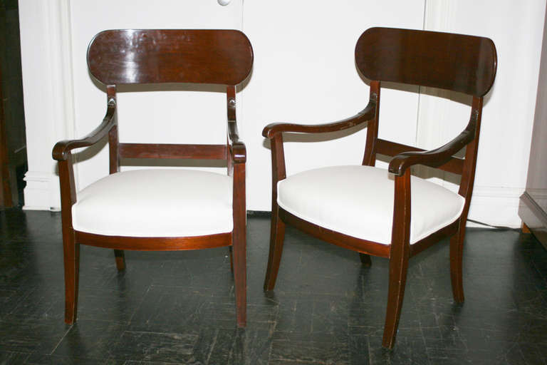 Pair of 19th century mahogany slipper chairs with concave tablet cresting, downswept arms and saber legs.