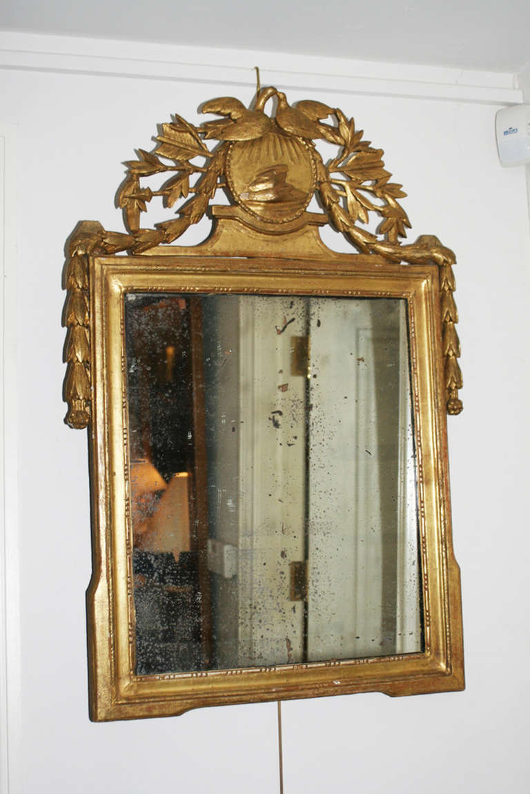 19th century carved giltwood mirror, the medallion cresting with foliate pendant, adorned with birds and bell flower decoration.