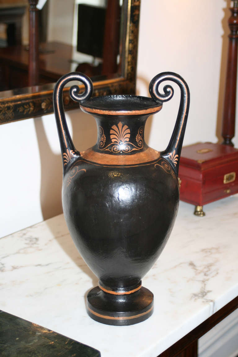 19th century black painted terracotta Amphora shaped vase with slightly twisted inturned handles.