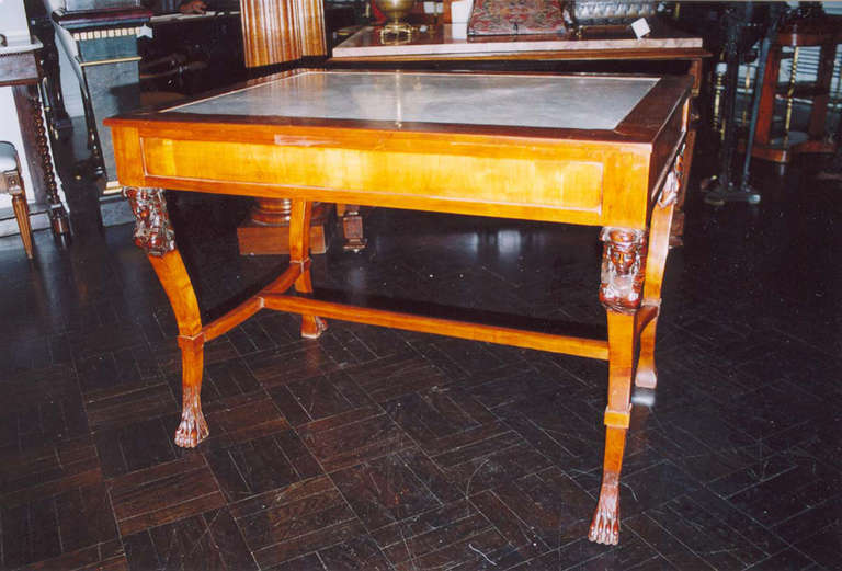 19th century Empire centre table inset with white marble top, mahogany surround and panelled apron supported by carved sphinx caryatids, incurved legs terminating in carved paw feet joined by 'H' stretcher.