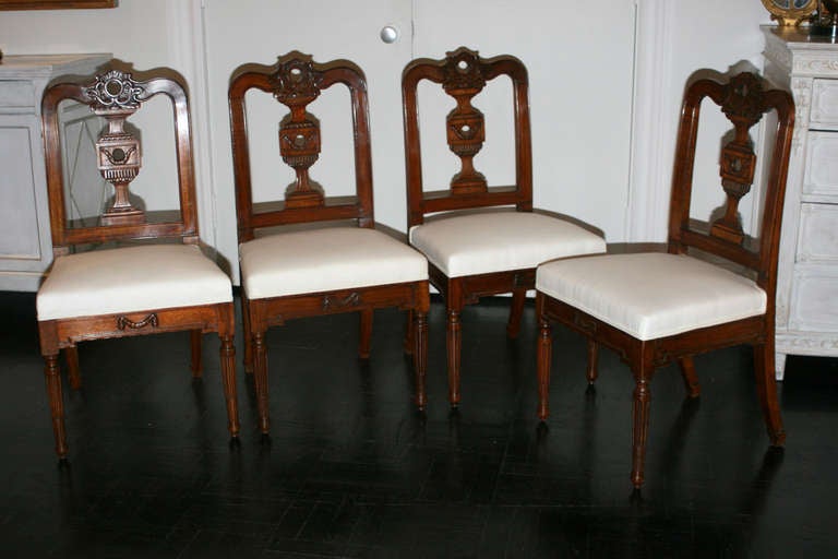 Set of four, 19th century mahogany dining chairs, rocaille cresting, urn splat swag decorated apron, round fluted legs.