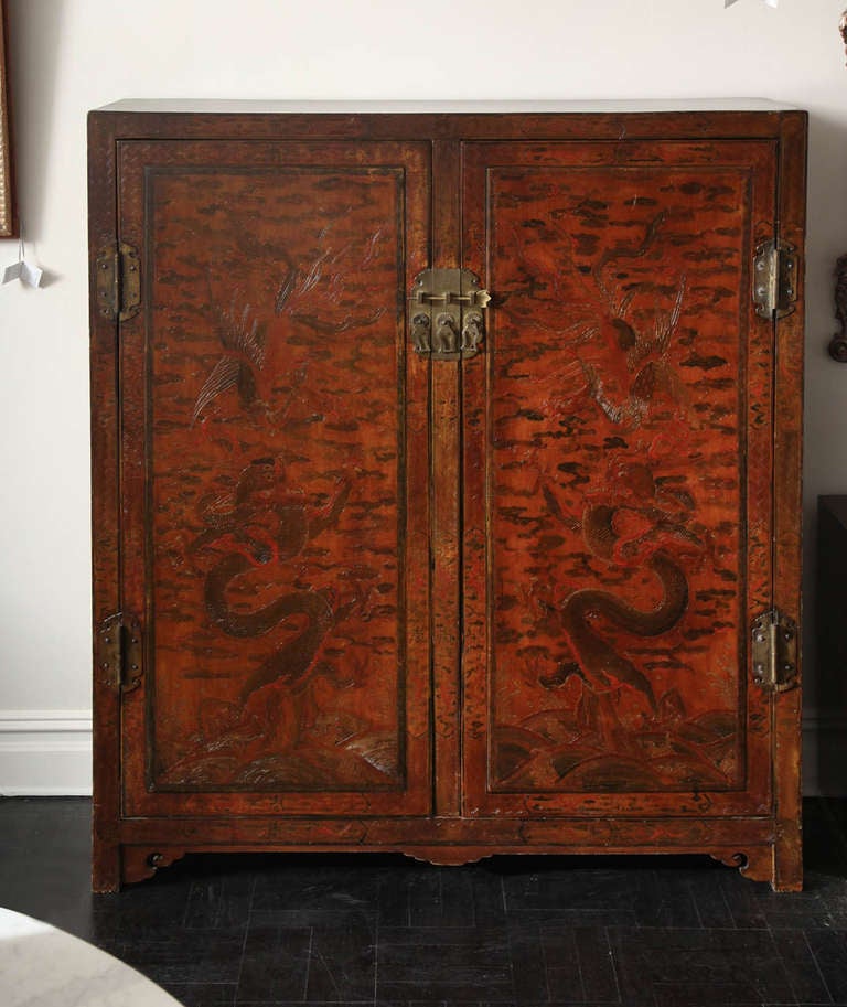 Mid-19th century Chinese two-door cabinet, dark red, decorated and lacquered surface, engraved oriental hardware.