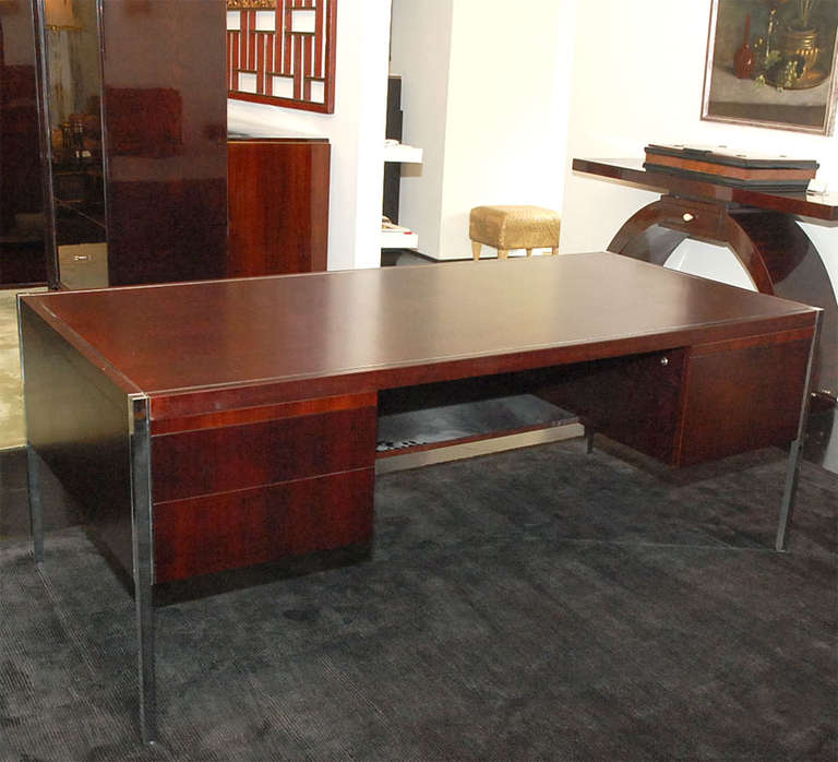 Beautiful mahogany Knoll desk with chrome detailing and legs. Unique, clean and architectural piece. Plentiful storage along sides with file drawer, storage drawers and pull out extensions. 