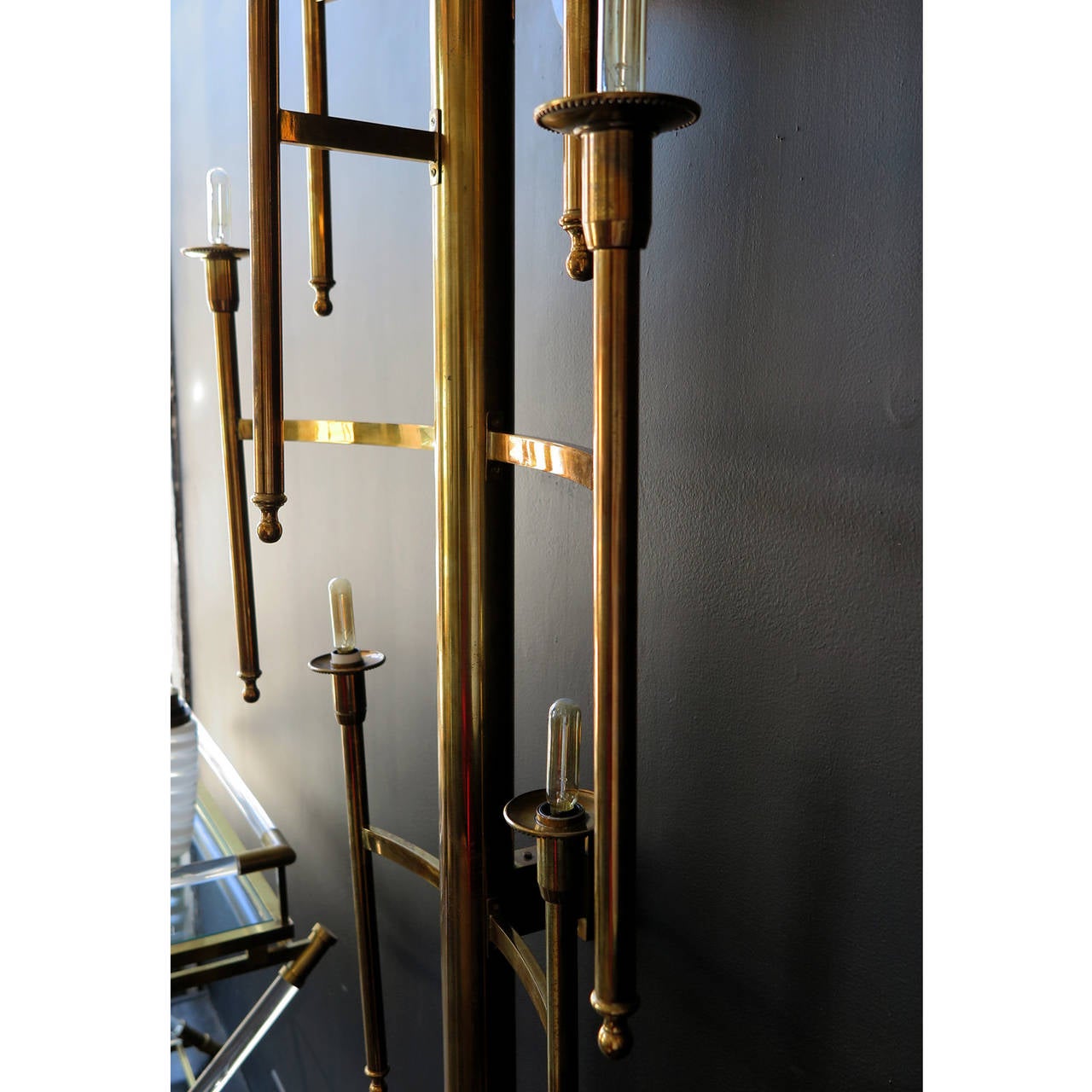 Impressive pair of torch style sconces in antique brass. Oversized in scale. Top and bottom are capped with round brass balls. Each sconces has seven arms.