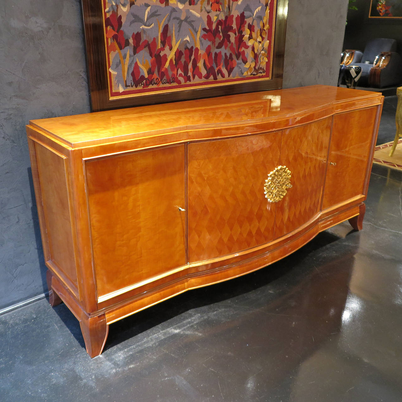 Beautiful sideboard by Jules Leleu and Paul Henri Goulet. Piece done in sycamore with diamond marquetry details on front doors. Center doors decorated in stylized leaf carving on facade in gold leaf. Side doors open to drawer and shelf. Center doors