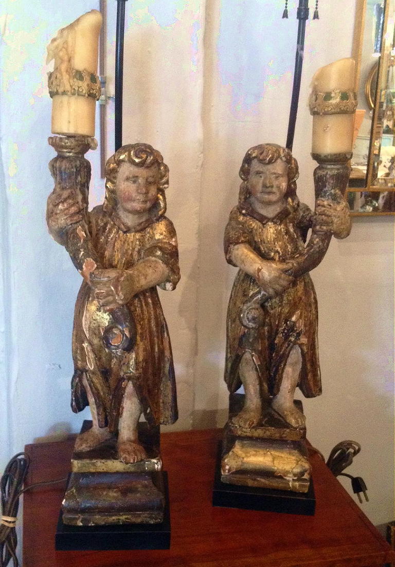 A Pair Of Carved Wood, Gilt And Painted Candle Bearing Angels Now Mounted As Lamps.