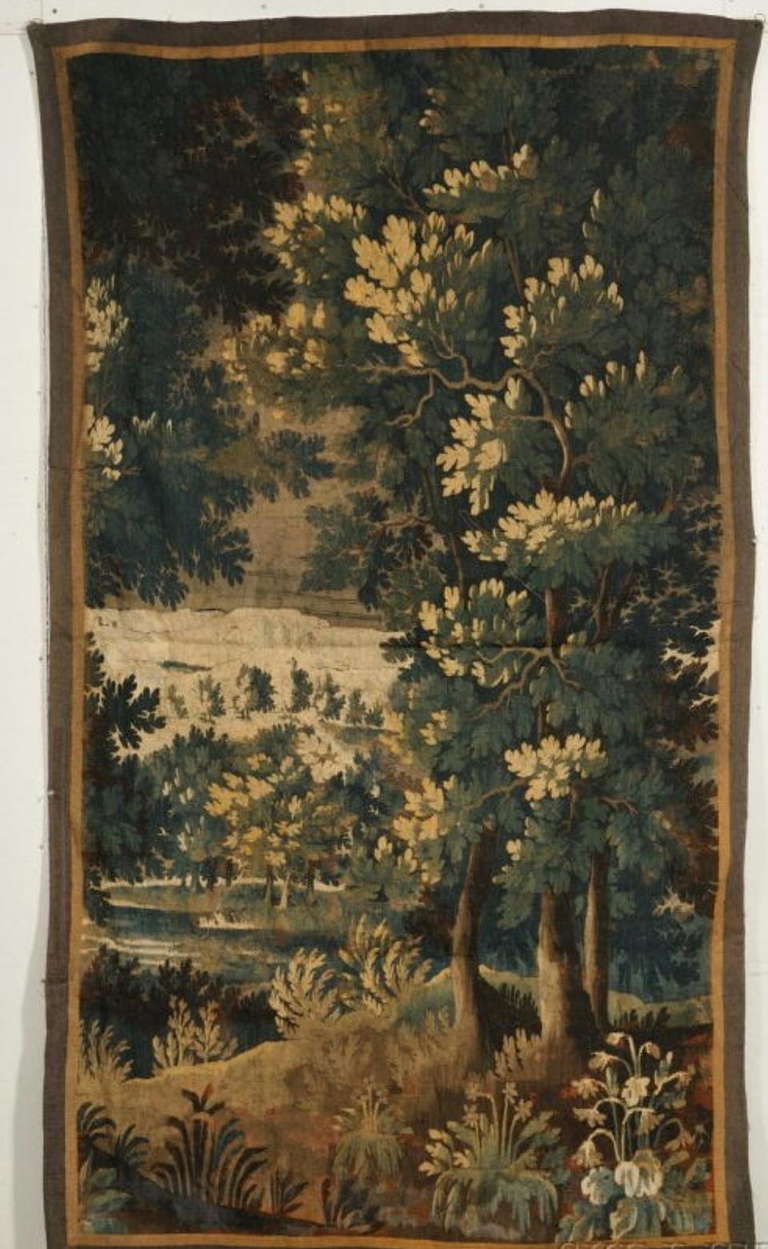 Flemish or French verdure tapestry fragment, 17th-18th century, depicting a lushly wooded landscape, with cotton backing.