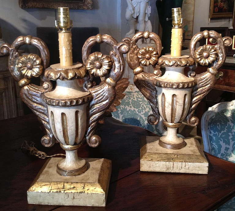 A pair of carved gilt and painted Italian urn form lamps.