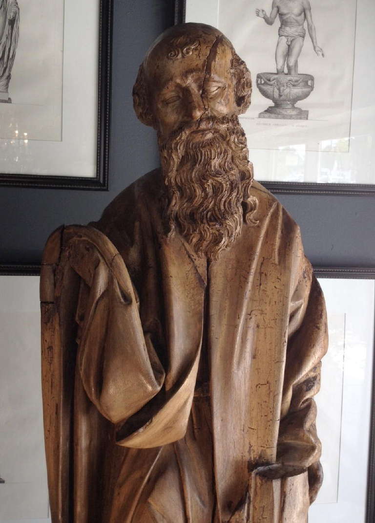 A Dutch Renaissance Carved Walnut Figure Of An Apostle With Flowing Beard Holding A Book.
