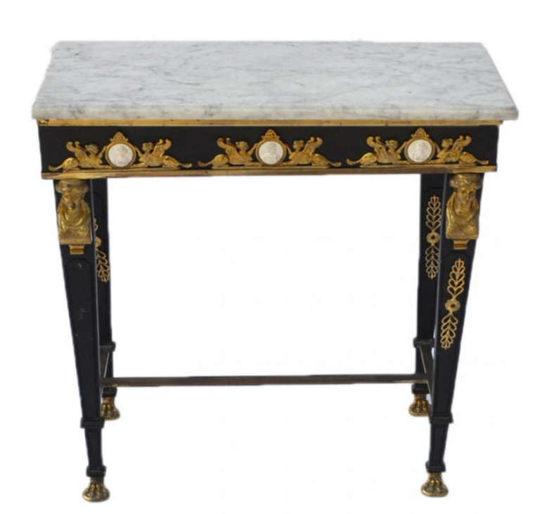 A French Empire style iron console table with a marble top. Mounted with bronze ornaments and bisque plaques.