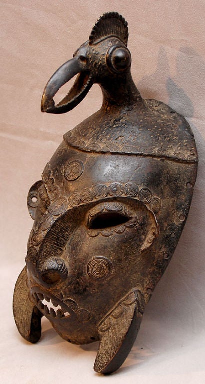 A fine African bronze war mask with caloa bird head decoration.