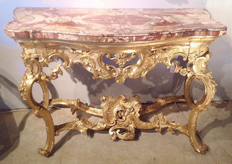 An Important Italian Baroque Gilt wood Console Table With Sicilian jasper Veneered Top

Rome Early 18th Century 
The thick, book matched top of rare, iron red Sicilian Jasper above a remarkably carved apron with scrolls and foilage flanked by