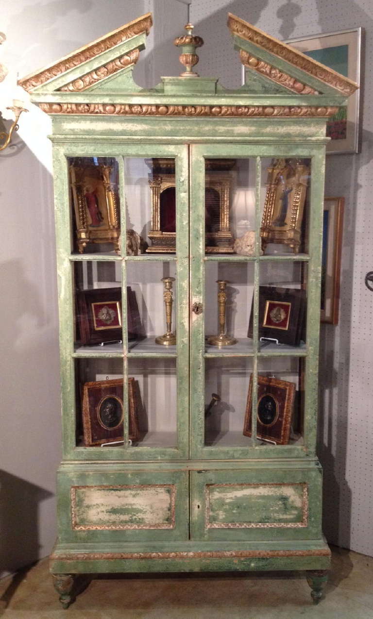 An Early 20th Century Italian Painted And Gilt Wood Display Cabinet With Two Framed Glass Doors And Glass Side Widows Above. Two Cabinet Doors Below. On Turned Feet.