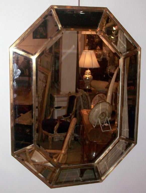 A pair of Mid Century beveled glass brass framed mirrors.
