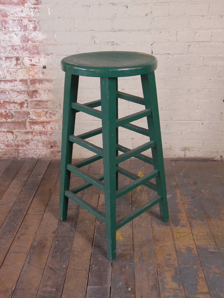 Vintage painted green wooden shop factory stool. Seat diameter is 14".