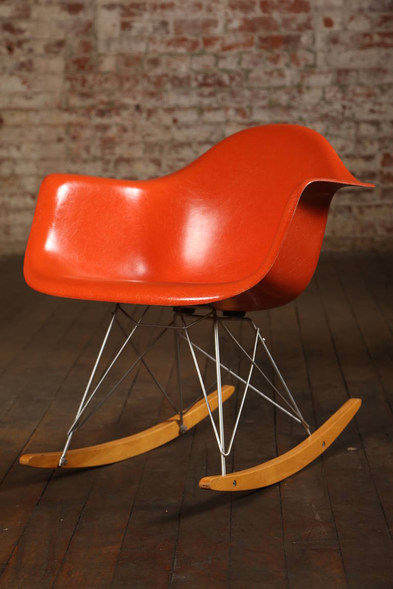 Mid-Century Modern. Orange fiberglass shell rocking chair. Made with wood, steel, and fiberglass. Chair measures 27