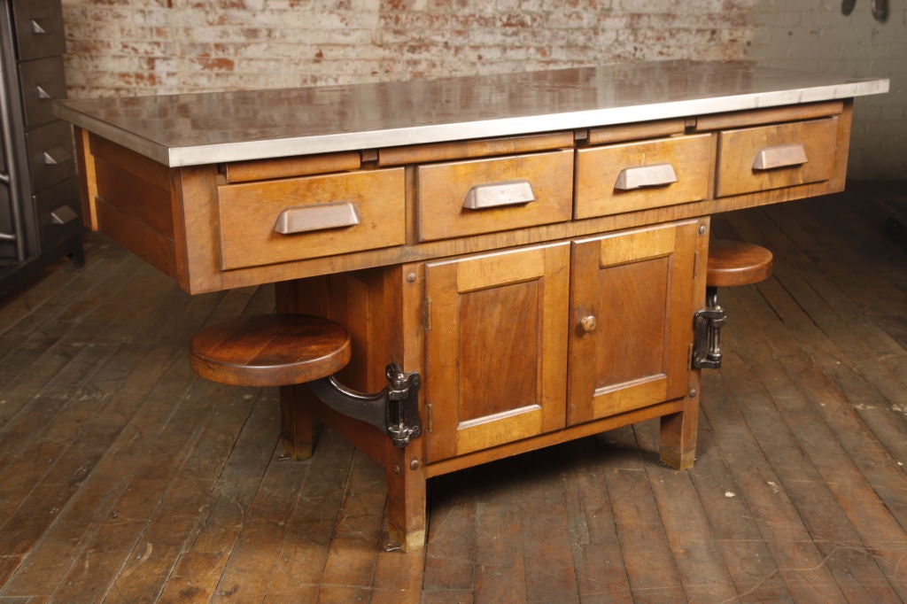 Original Vintage Industrial, American Made School Lab Desk with a stainless steel top, four pullouts, four dovetail drawers, two cabinet doors and two cast iron 16