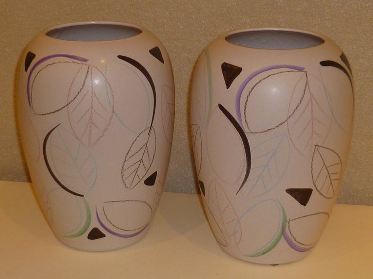 Great scale modern German pottery vases by Scheurich. Featuring a conga shaped bulbous body hand decorated underglaze with stylized leaves in pastel crayon like strokes and watercolor type brushstrokes. A matching pair with sight decoration