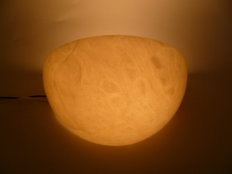 From 1970s, Spain, this pair of half moon wall lights are quite beautiful and absolutely look like alabaster with their random organic swirls and translucent stone like glow. Wall lights that are appropriate with every period of decor. Each with a