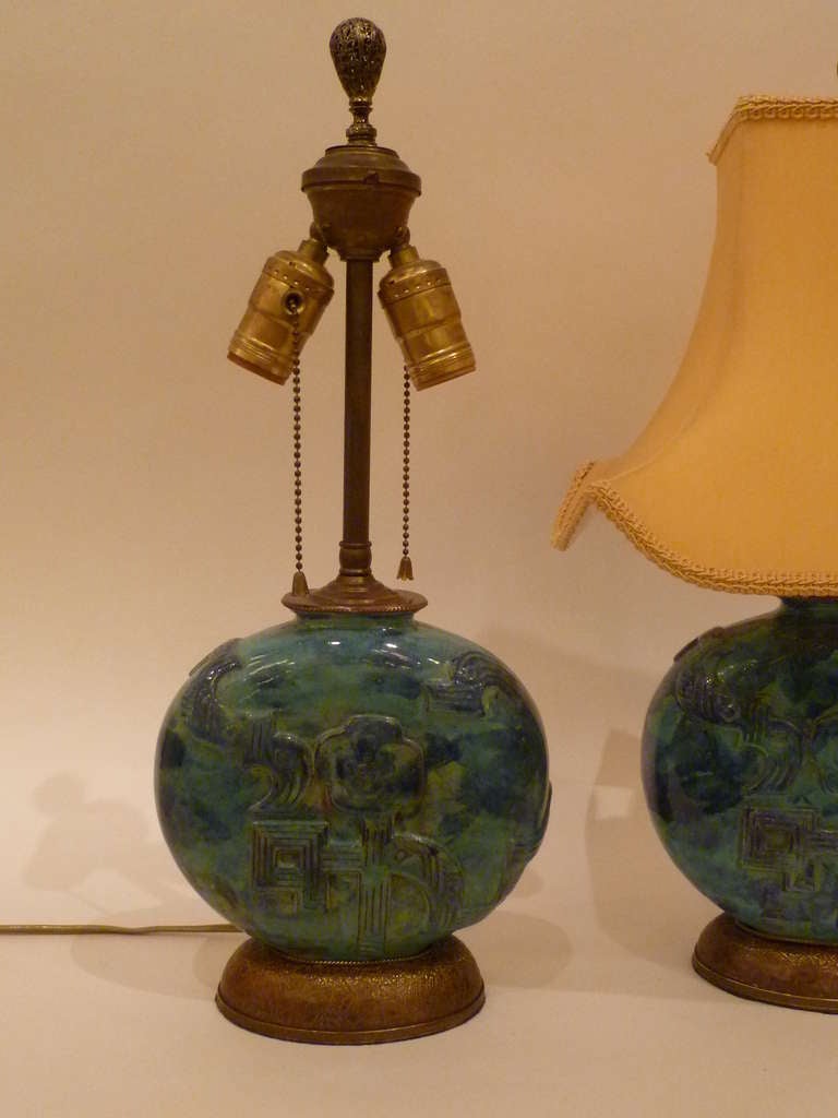 REDUCED FROM $4500....Wonderful pair of Wiener Werkstatte table lamps of hand glazed pottery vases by Vally Wieselthier featuring a moon shaped form with a stylized floral design in relief, mounted on bronze bases with a repeating oak leaf