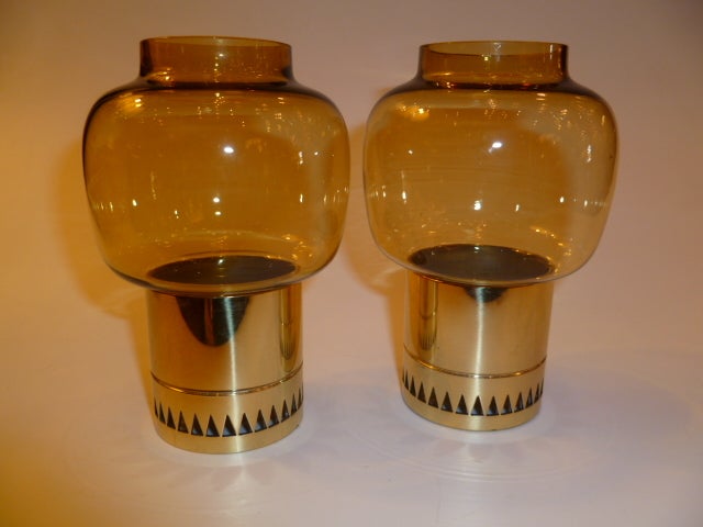 SOLD FEB/2013...Beautifully rendered in brass, this modernist petite pair of Hans Agne Jakobsson hurricane lamps have a art deco design influence and have fine hand blown swedish amber glass globes. The brass bases have a reticulated triangular