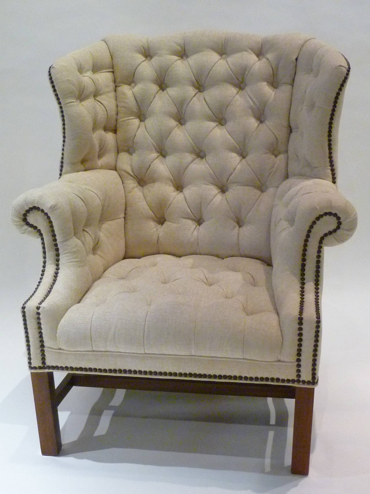 SOLD  Beautifully upholstered in a creamy chenille fabric, this pair of large-scale wingback armchairs are room anchors. Deep and comforting, they feature multiple tufting and nailhead finishing. Deep cove back in the style of Edward