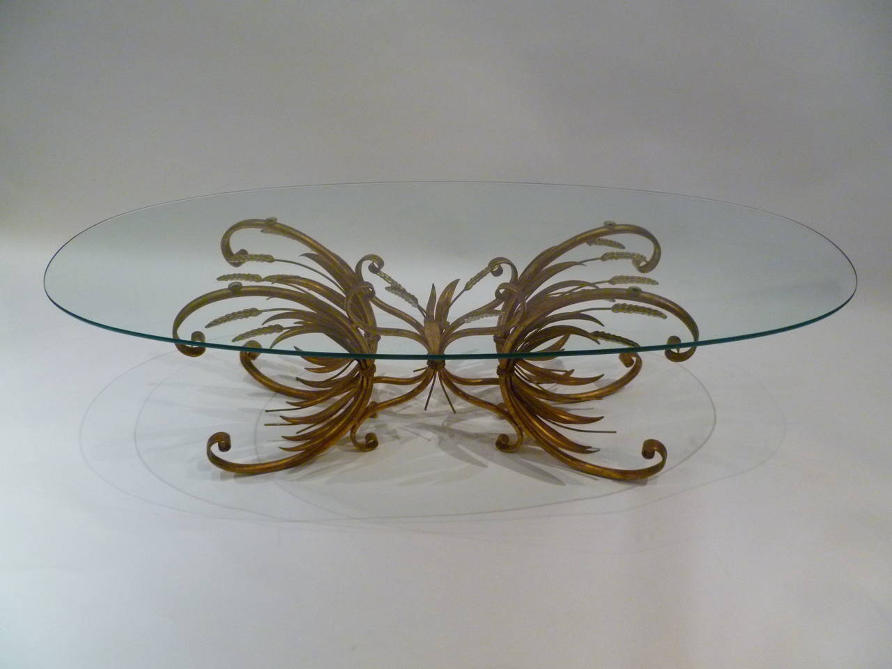 SOLD Rare and unexpected elongated Coco Chanel style double sheaf of wheat cocktail or coffee table. Presently with an oval glass. Beautifully gilt, wrought and sculpted C-scrolls, leaves.

For trade pricing and shipping please contact