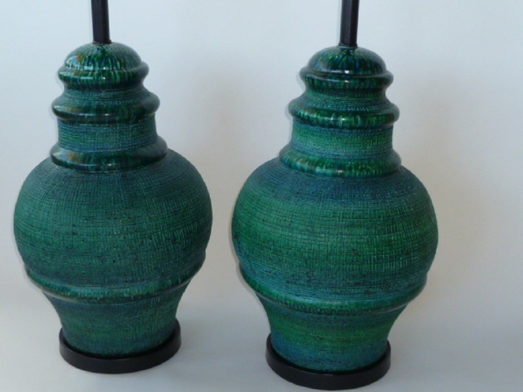 A large-scale stylized temple jar shape here with this pair of Italian pottery table lamps with a blue green glaze over a sgrafritto incised pottery reminiscent of Aldo Londi's Bitossi designs and his Rimini blue color. Just add your