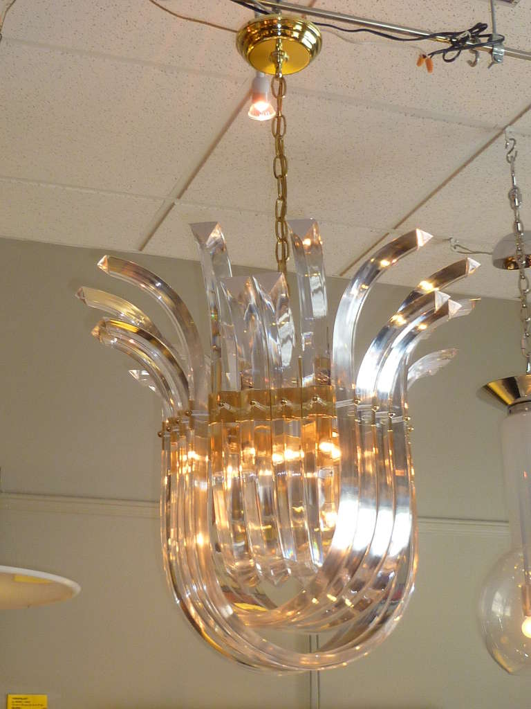 SOLD  With a dramatic three tiers of swagged Murano style lucite crystals overlapping and extending upward into a crown form.   Impressive and exciting!  Brass mounts, chain and canopy.
Has eight (8) candelabra size lights, 60 watts max