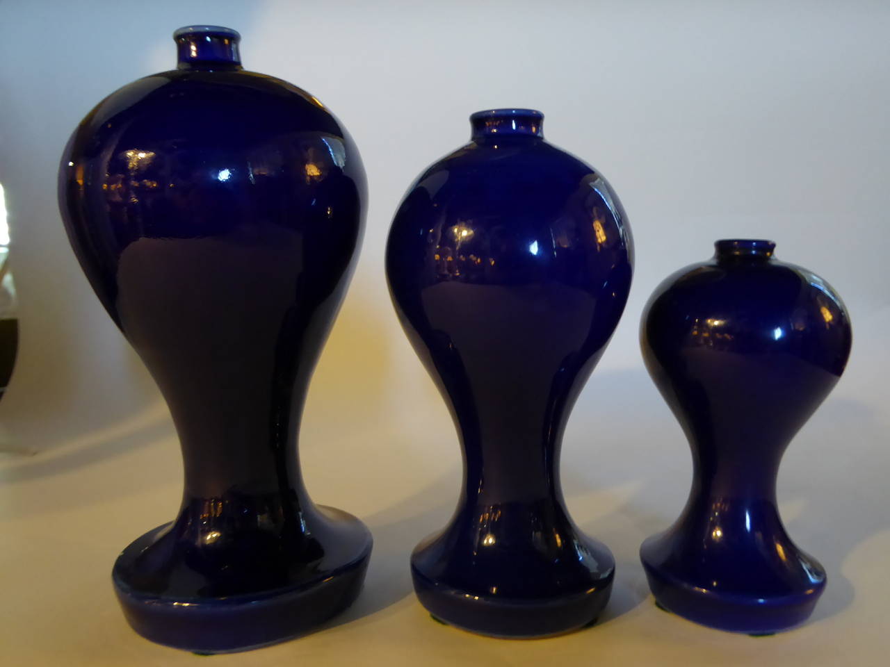 Set of three inspiring Japanese cobalt blue glazed pottery altar vases in three sizes. Created in the late 1930s during the Showa period (1926-1989).

Dimensions: 7 1/2" H x 3 3/4" diameter.
6 1/2" H x 3 “diameter.
5" x 2 1/2