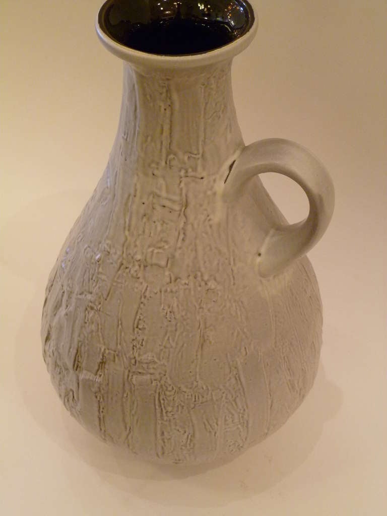 Dating from 1956, this rarely seen Mid-Century very textured and large German krug vase by Clemens & Huhn predates the coming hot lava days and exhibits a Classic urn form with a ear handle. With a bark like woody exterior in a neutral pale gray