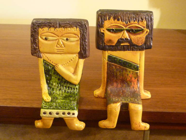 Whimsical pottery ceramic offering from Marcello Fantoni for Raymor of shelf sitters depicting a pair of flirting ancient toga clad man and woman. Often described as cave people, their outfits suggest a more evolved society, say Babylonian or Greek.