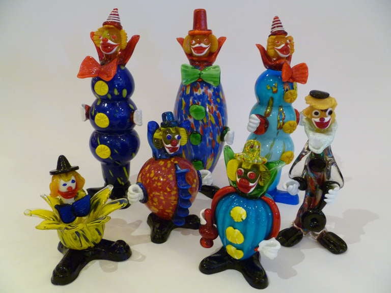 An instant collection and such fun with this grouping of seven midcentury Murano glass clowns in a riot of color and form. Happy faces and costumes, they include three tall fellows and four more varying in height and dress. Several retaining gold