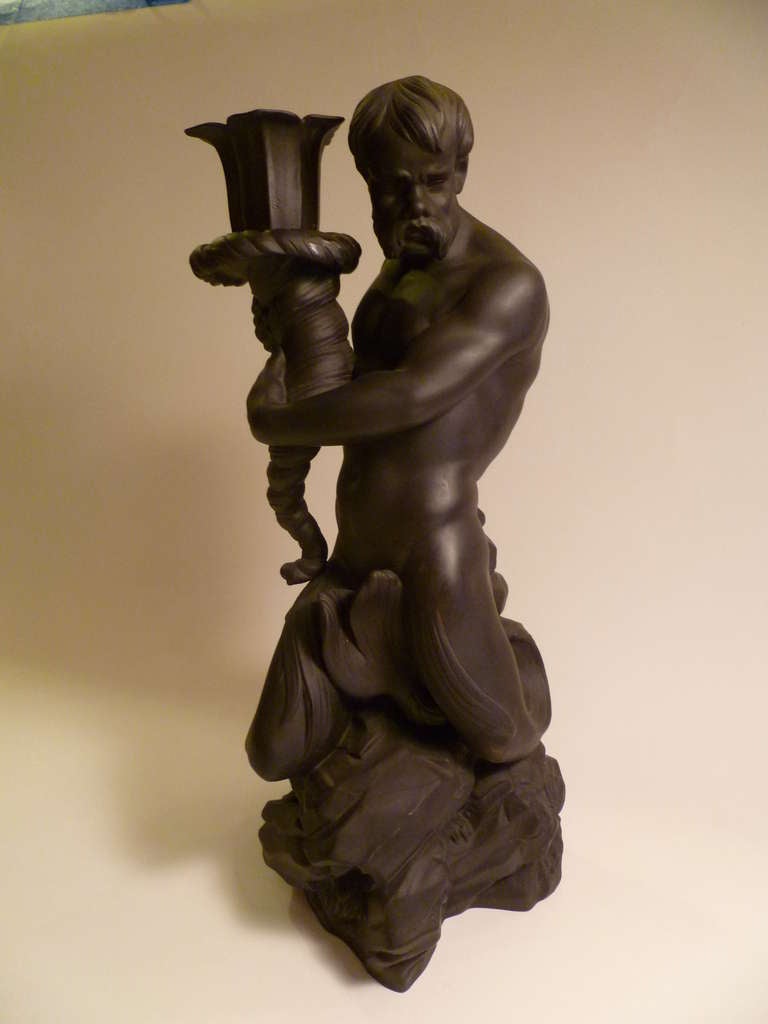 SOLD  After a model by John Flaxman for Josiah Wedgwood, this Triton holding a cornucopia candlestick is in Wedgwood black basalt.  Beautifully rendered, the muscular half man/half fish Triton is perched on a rocky crag, wonderfully detailed