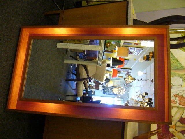 SOLD   A warm & dazzling illuminated shadowbox teak mirror by Pedersen & Hansen, a mid-century Danish firm, creators of significant Danish modern mirrors and decorative accessories.  This long mirror features a deep shadowbox teak frame with a