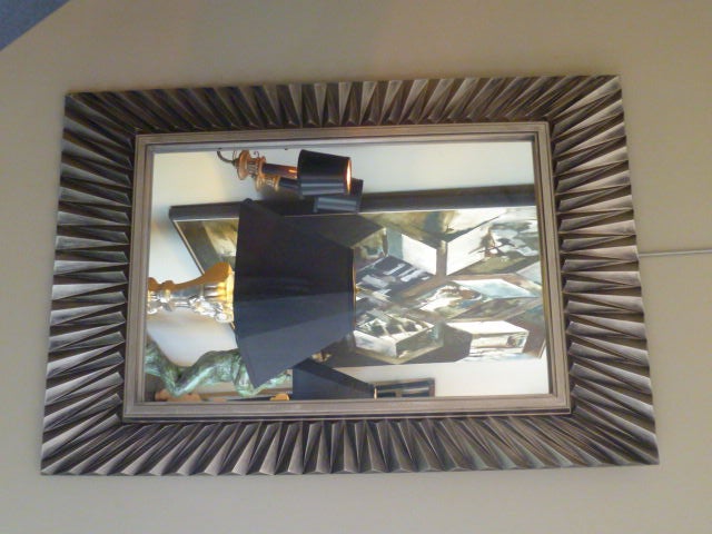 SOLD NOV 2011 Strong, modern and elegantly futuristic, this mirror made by Syroco in 1978 has an incredible presence with its geometric, metal posturing...its Escher-like repeating design and wonderful steely color and shading.  Very modern, very