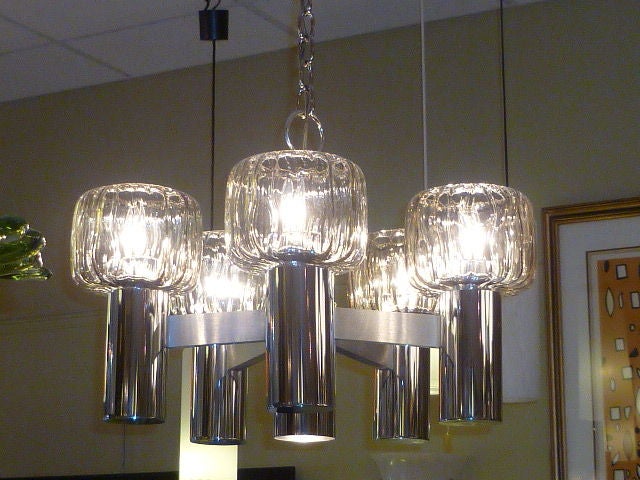 Unusual and bold, this Lightolier chandelier has five fat mold blown glass globes creating an exciting light and visual. The five nickeled candles extending from brushed nickel arms from the center, are topped with blown globes of thick glass, most