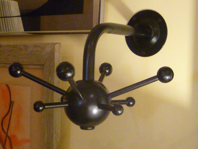 ...SOLD JULY 2012...Fun, modernist wall mount coat hook or rack by Osvaldo Borsani.
Comprised of a modern sputnik form, large rotating black wooden orb with radiating ball end arms of alternating lengths.
This on a curved black enameled steel tube