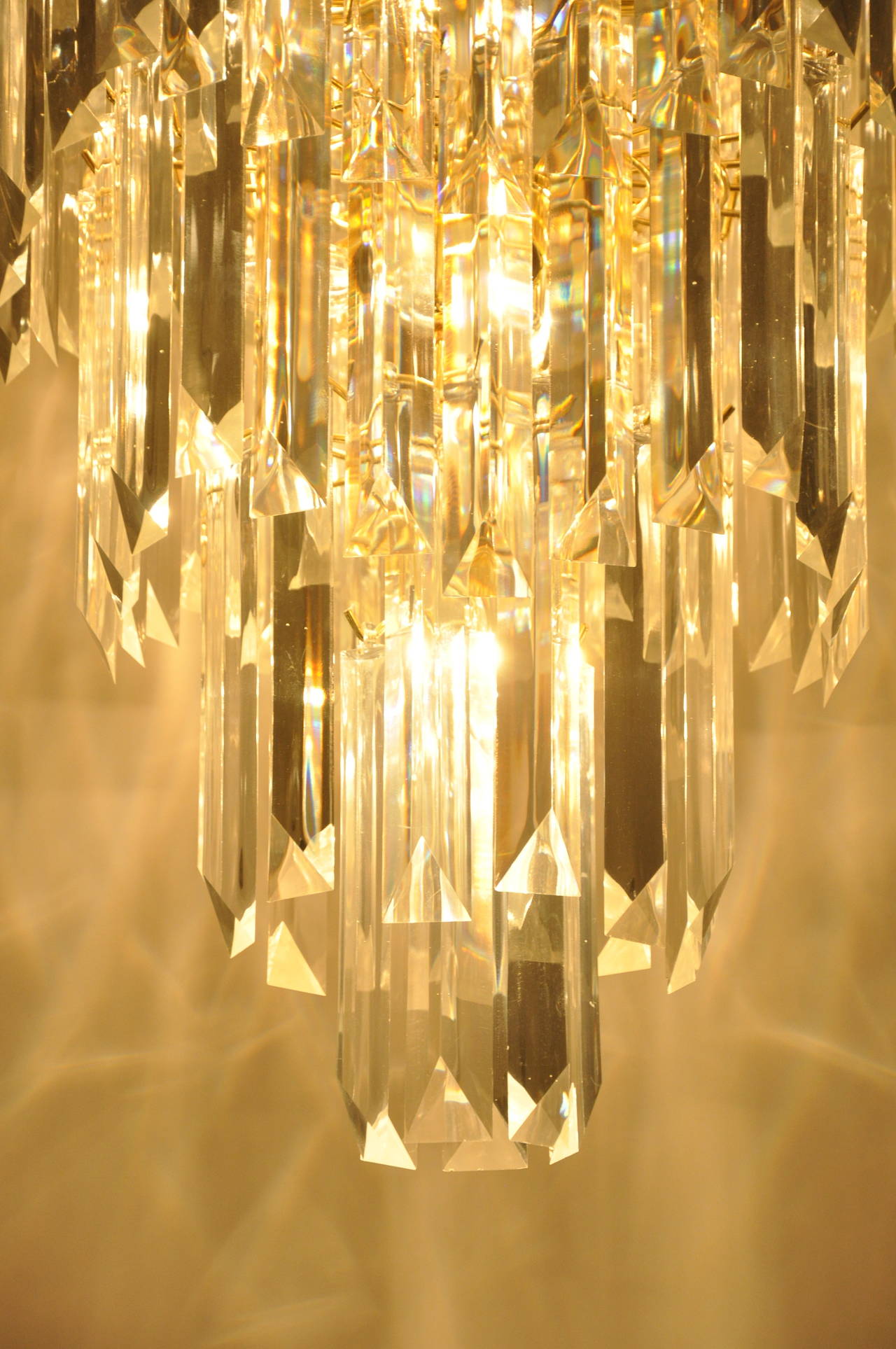 Five-tier Mid-Century Lucite chandelier. It circles around in a wave like pattern. 
There are 14 bulbs.