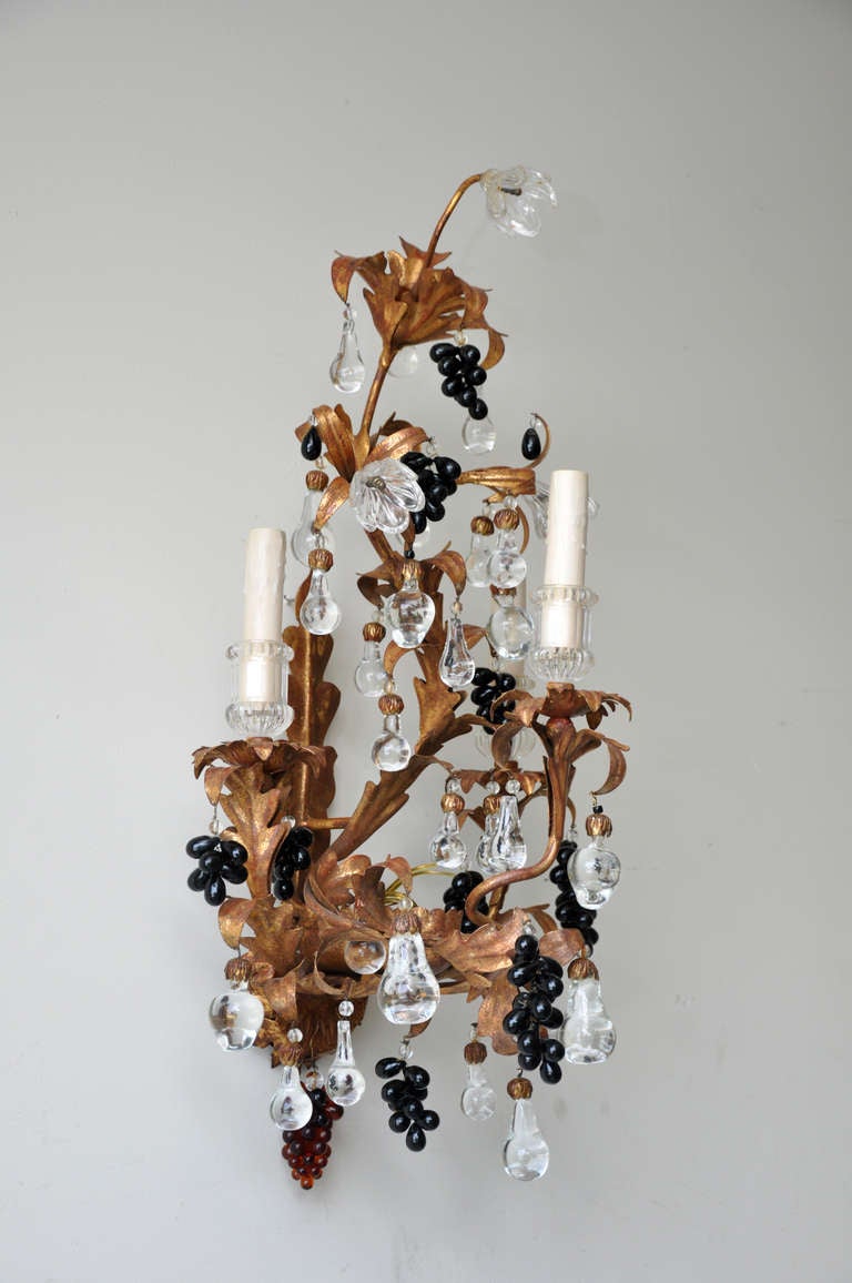 Beautiful pair of 19th century Italian gilt tole and crystal sconces.

Each four-light sconce adorned with a combination of hanging clear glass flowers and fruit, colored grape clusters, and glass bobeches. 

Purchased from Paul Ferrante (Los