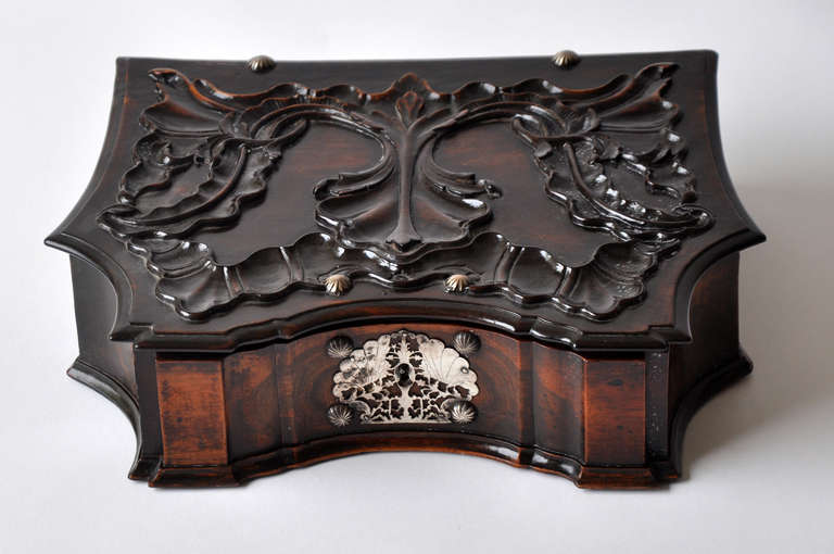 Handsome 18th century Portuguese rosewood box with original sterling silver mounts. Solid rosewood with deep relief carving to top lid of box. Period silver escutcheon found on front key lock, side handles and back hinges. Interior clean, divided