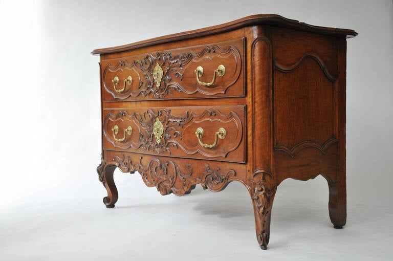 Beautiful 18th century French two-drawer walnut commode with original bronze hardware, circa 1760. 

Wonderful hand-carved detail on drawers, apron, and legs made by master cabinetmaker from the Toulouse region in the South of France.

Rich
