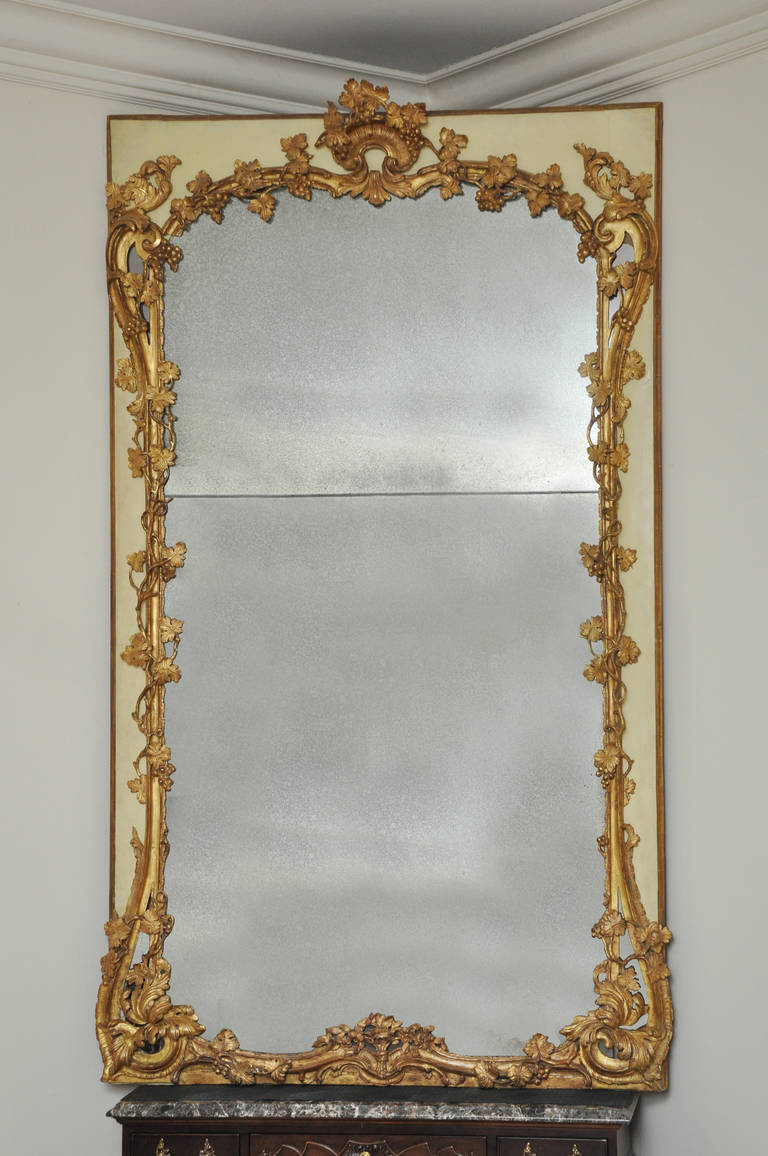 Magnificent hand-carved 18th Century French Chateau Mantel Mirror. Original painted surround in creme color. 

Beautiful giltwood mirror found in a large chateau from the Provence region of France. Elaborate grape/grapevine carvings transverse