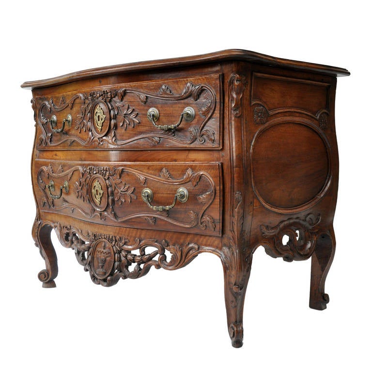 Exceptional 18th century French Provencal two-drawer walnut commode from Nimes (France). Chest of drawers crafted by master cabinetmaker with detailed hand carving on front, curved (galbe) front and sides of chest, and elaborate pierced aprons on