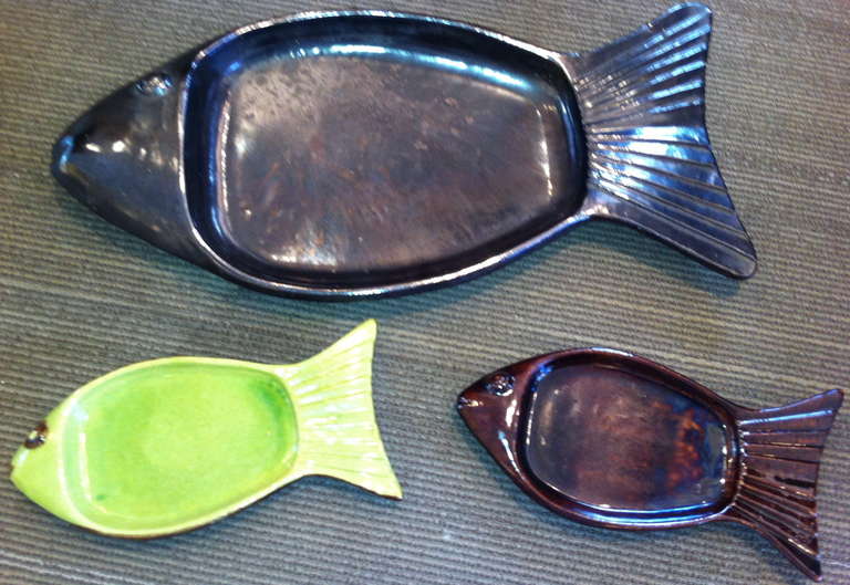 Rare set of vintage French serving pieces with fish motif.  Seven piece set includes one large platter in ebony and three each of the smaller fish plates in chocolate and green.