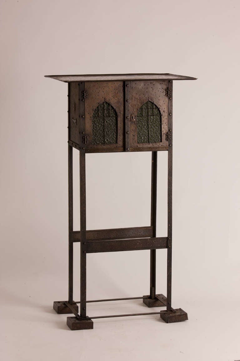 Wonderfully detailed metal table in the manner of Hoffman featuring two door cabinet with lock.