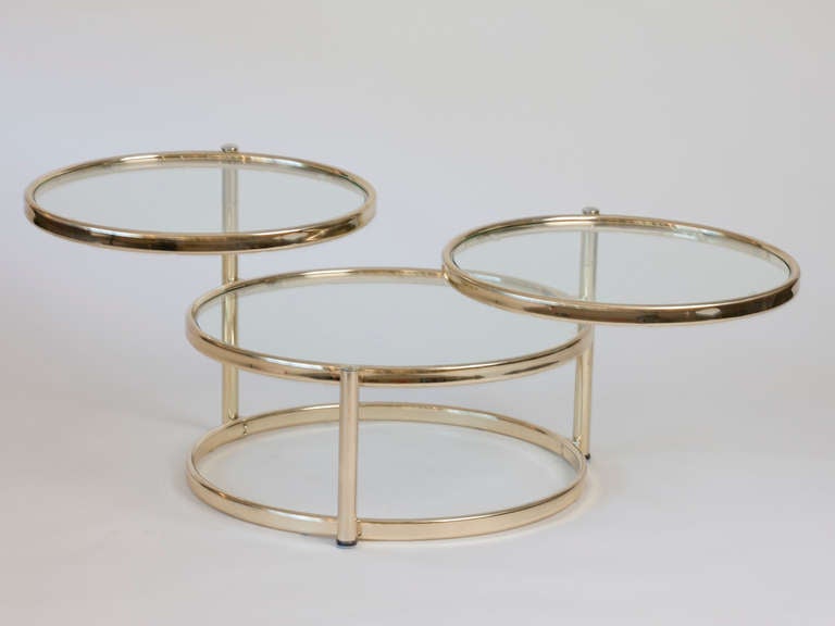 Brass and glass adjustable coffee table in the manner of Milo Baughman.  Top two tiers swing to stack or increase length.  Center tier is fixed.