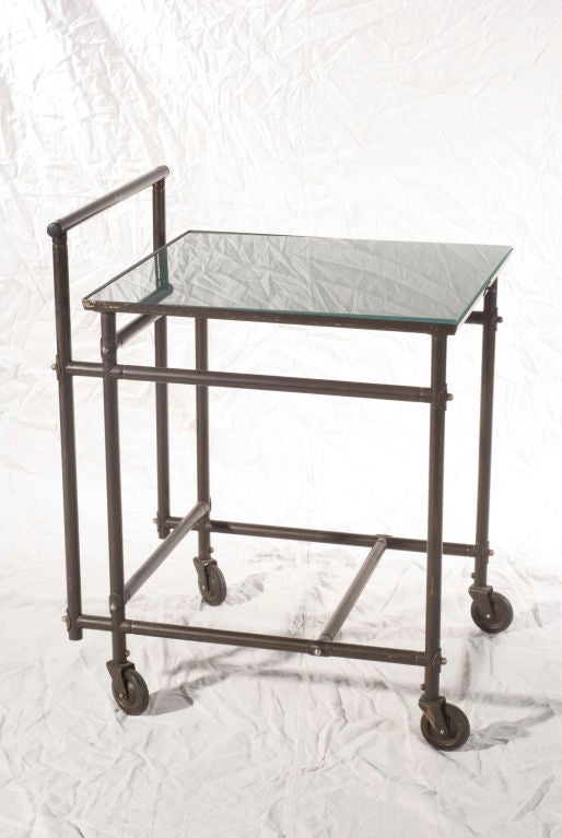 Rare industrial metal rolling cart by French designer Rene Herbst. Smoked glass tableau.